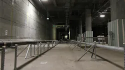 Two utility pipes run down the center of a future rail corridor, tracing the path where train tracks will eventually be laid. Two utility pipes run down the center of a future rail corridor, tracing the path where train tracks will eventually be laid.