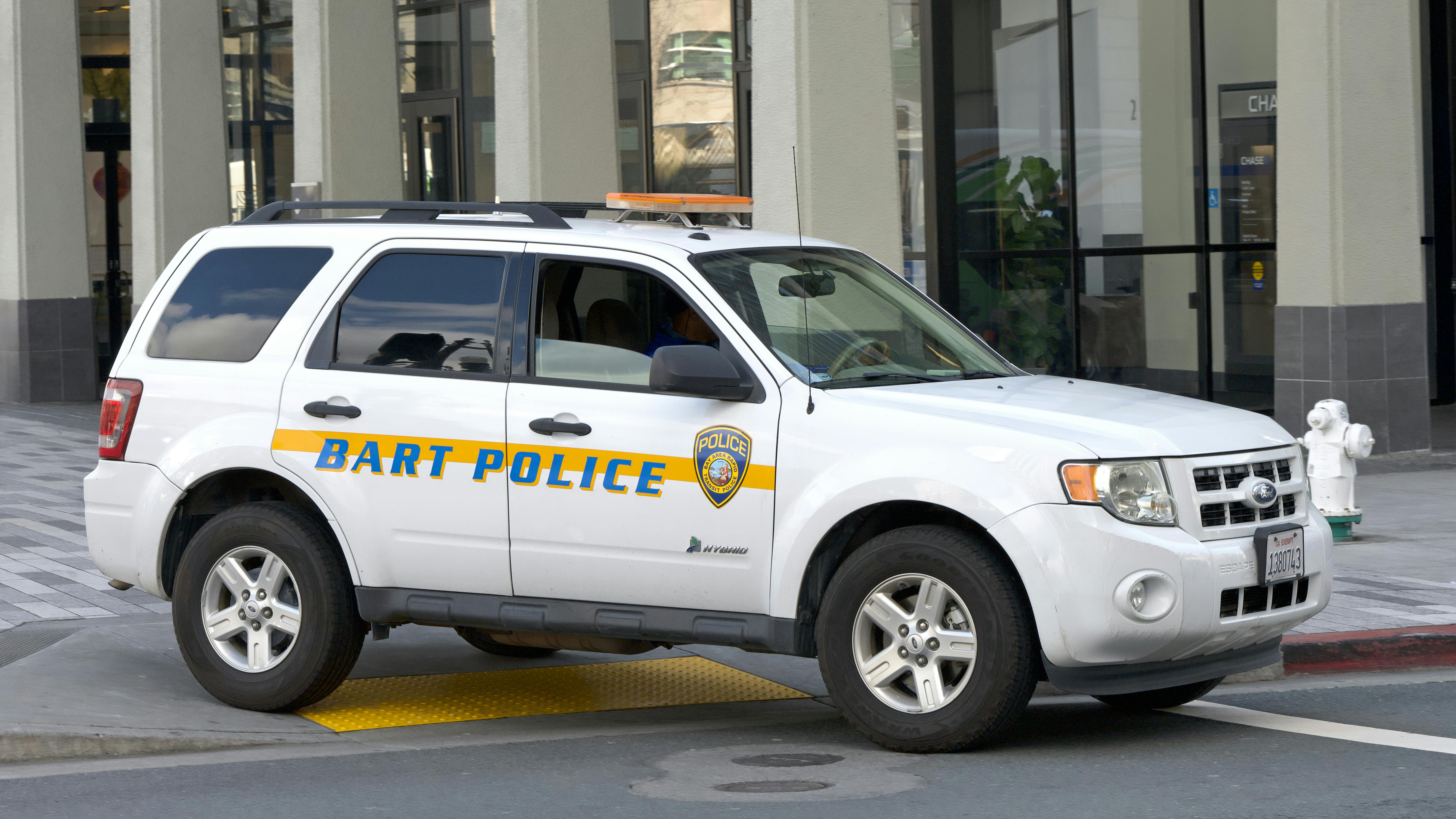 A Ford Escape wearing the BART PD livery sits in front of of a Berkeley station.