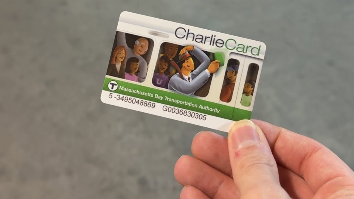 A hand holds an MBTA Charlie Card.