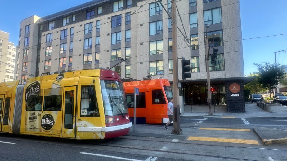 The image shows light-rail trains operating on the street.