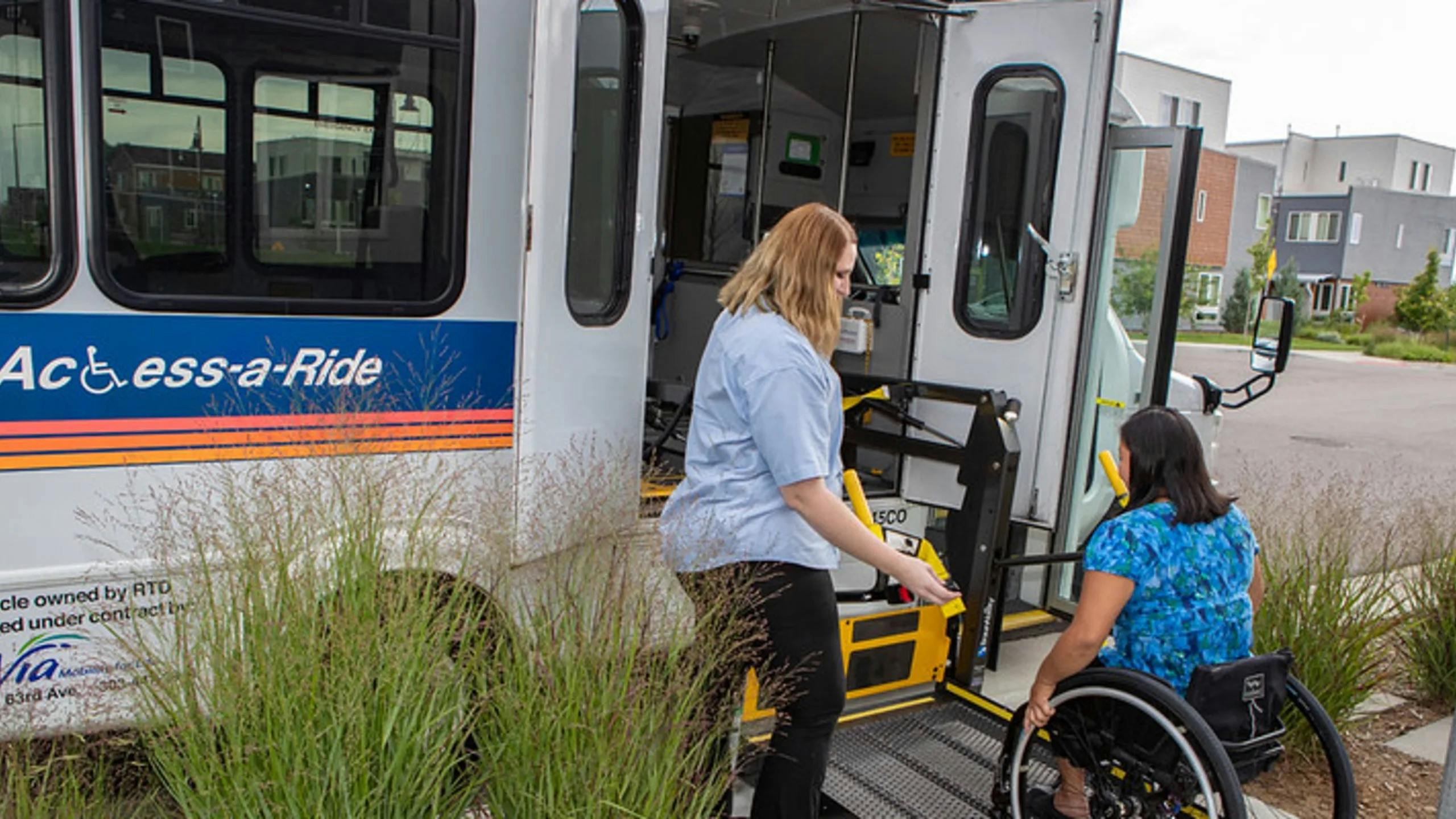 The image displays a woman helping a wheelchair user into a WAV vehicle.