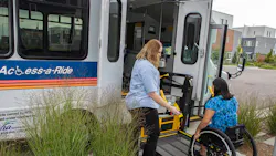 The image displays a woman helping a wheelchair user into a WAV vehicle. The image displays a woman helping a wheelchair user into a WAV vehicle.