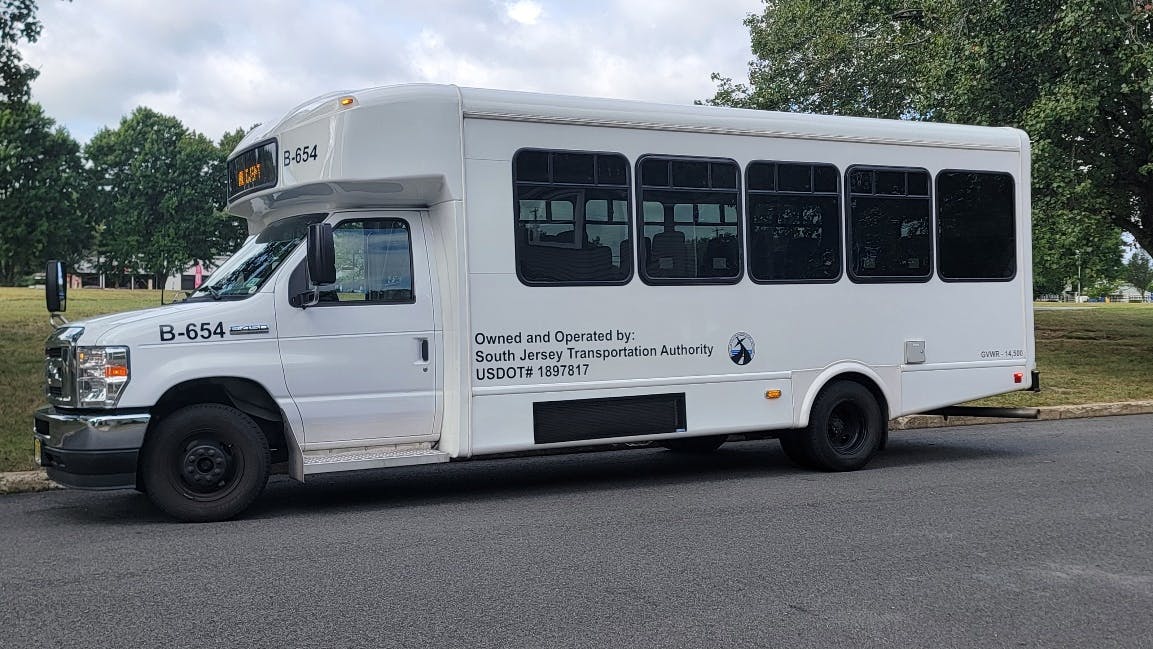 A white shuttle bus sits in a staging area.