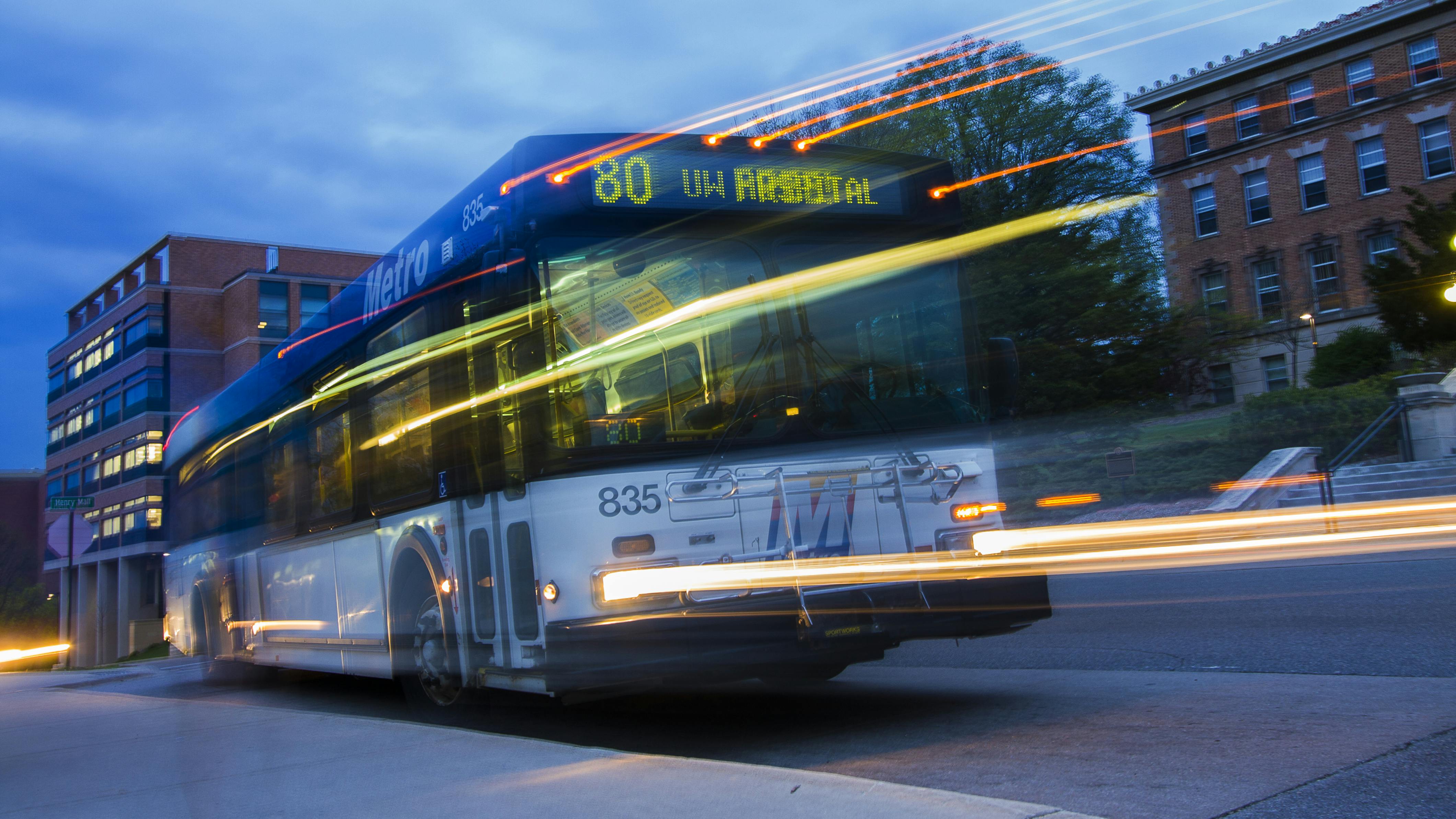Public transit bus whizzing by at night.