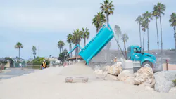 A truck dumps sand onto the beach. A truck dumps sand onto the beach.