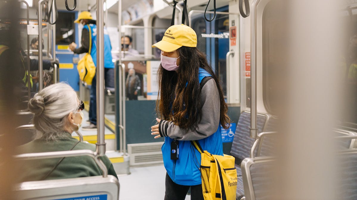 sound transit safety ambassador on rail vehicle interacts with rider