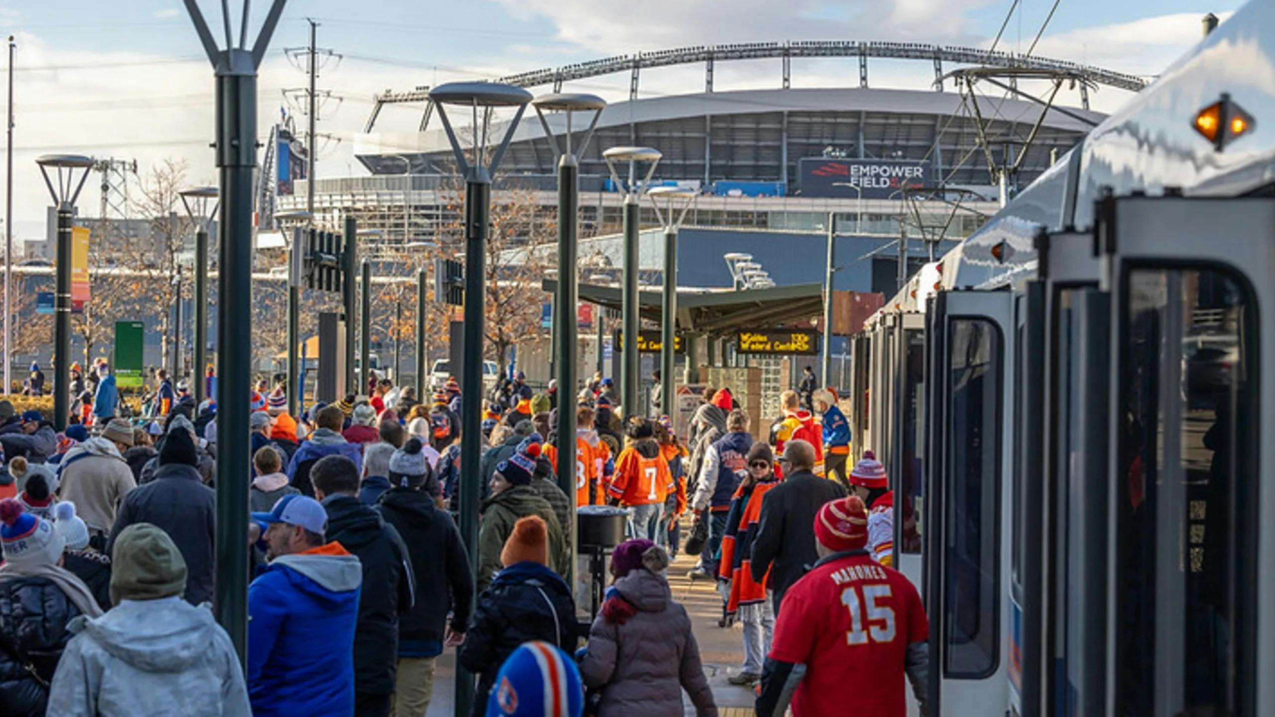 The image shows riders filtering off of public transit at a large event.