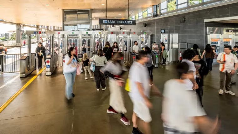 Riders enter a transit station.