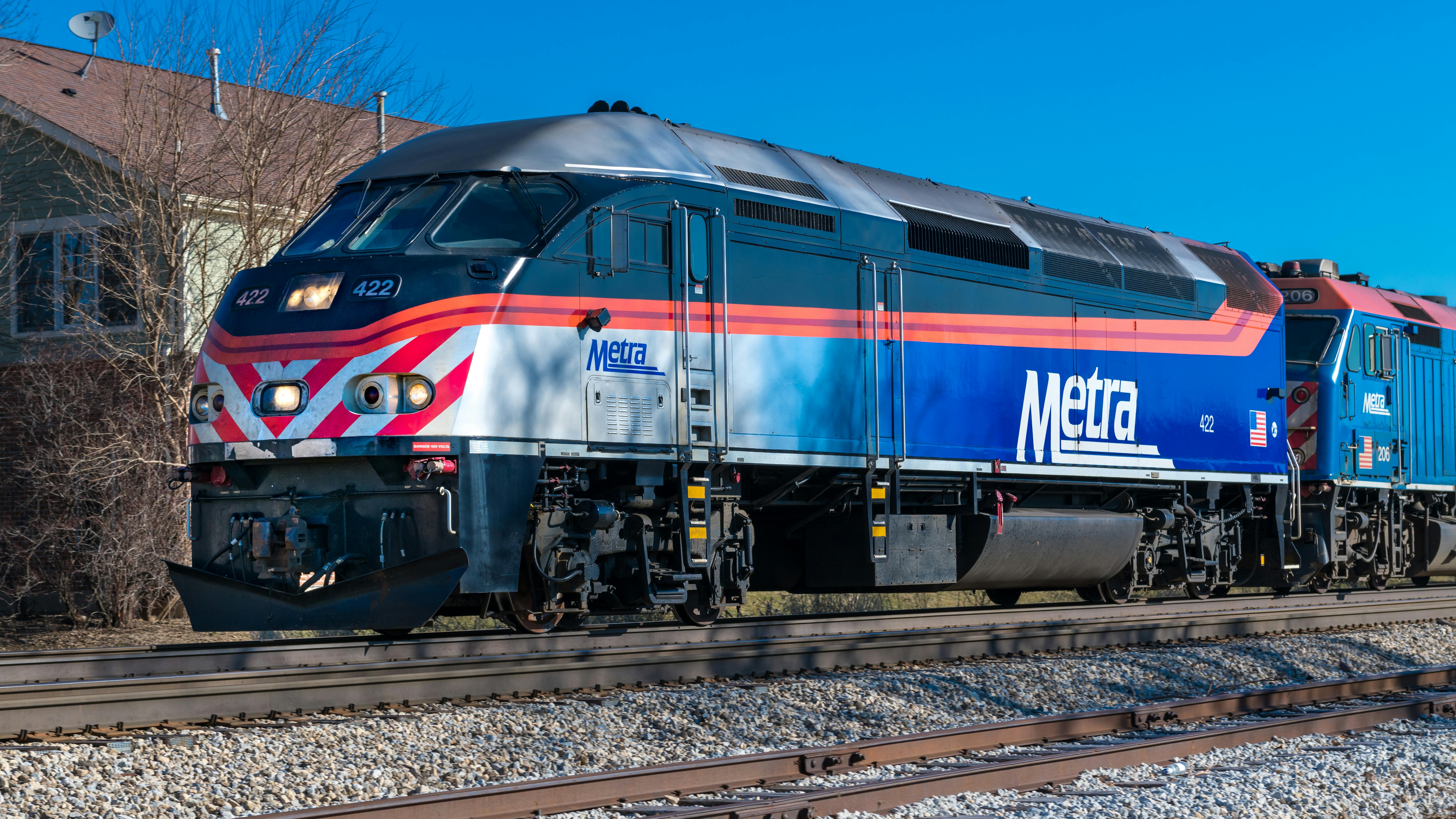 The image shows a Metra train moving along the track.