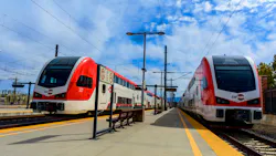 A pair of electric Caltrain trains sit at a station. A pair of electric Caltrain trains sit at a station.