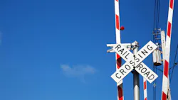 Railroad crossing sign against blue sky background. Railroad crossing sign against blue sky background.