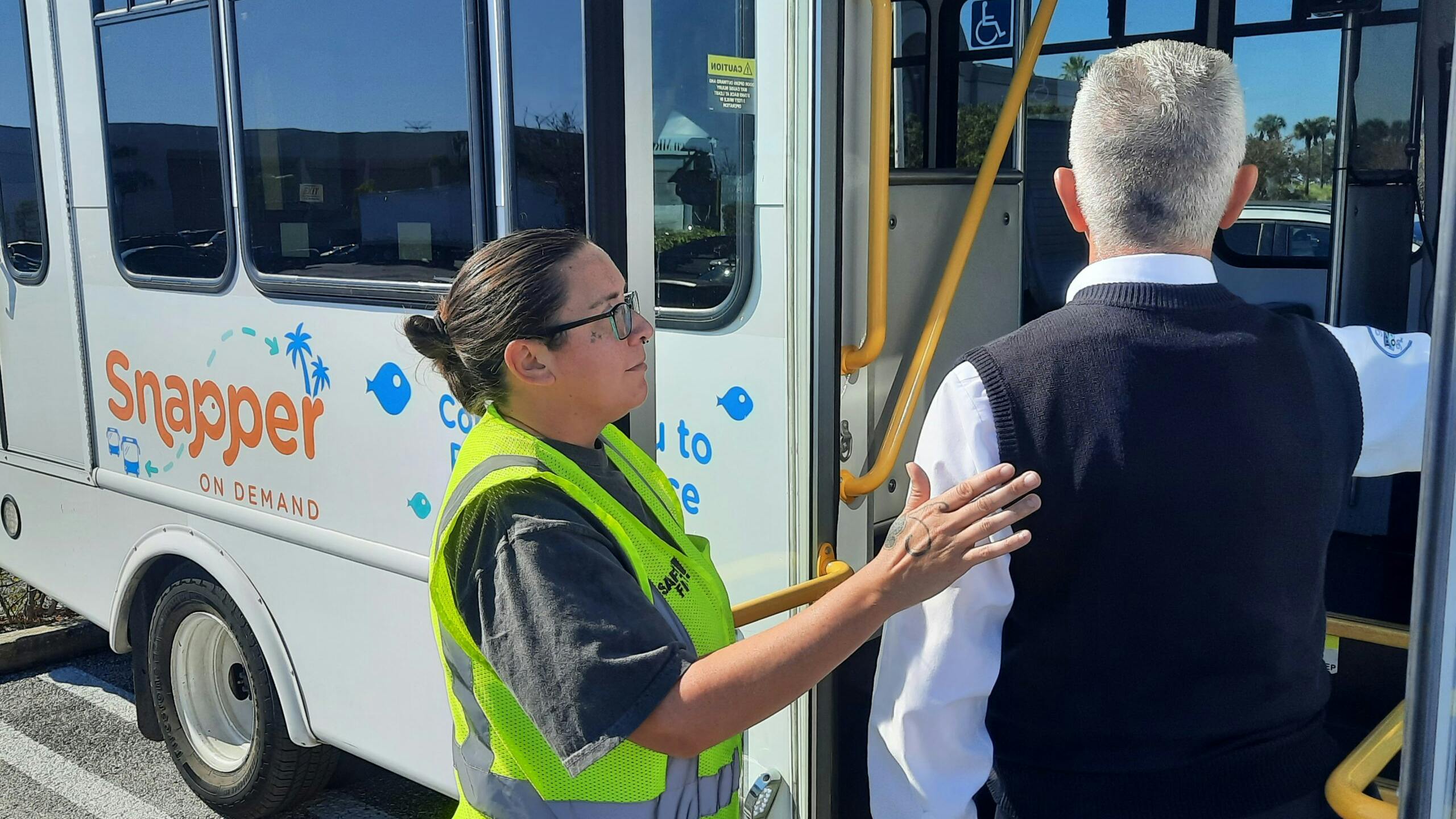 An operator helps a passenger onto The Snapper.