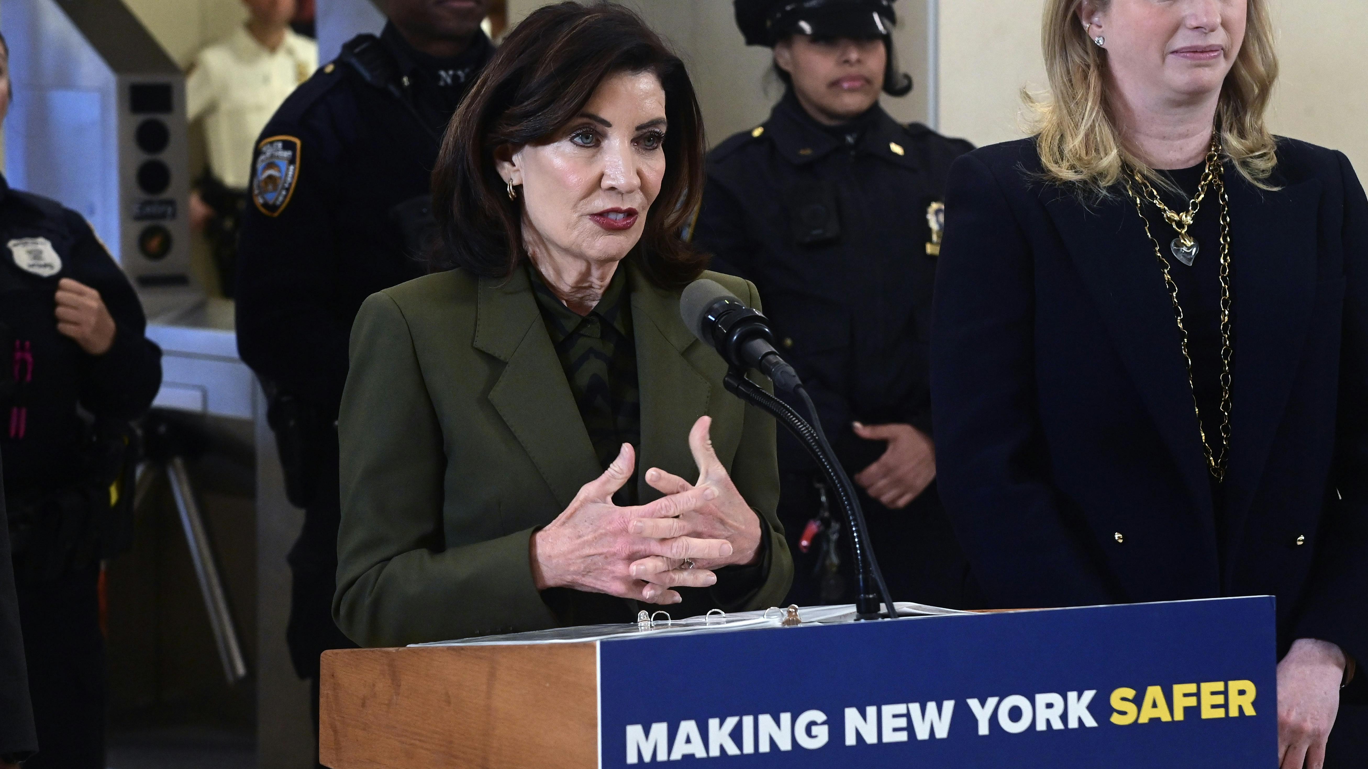 New York Gov. Kathy Hochul stands at a lectern speaking.