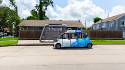 A microtransit vehicle sits parked in front of a stop. A microtransit vehicle sits parked in front of a stop.