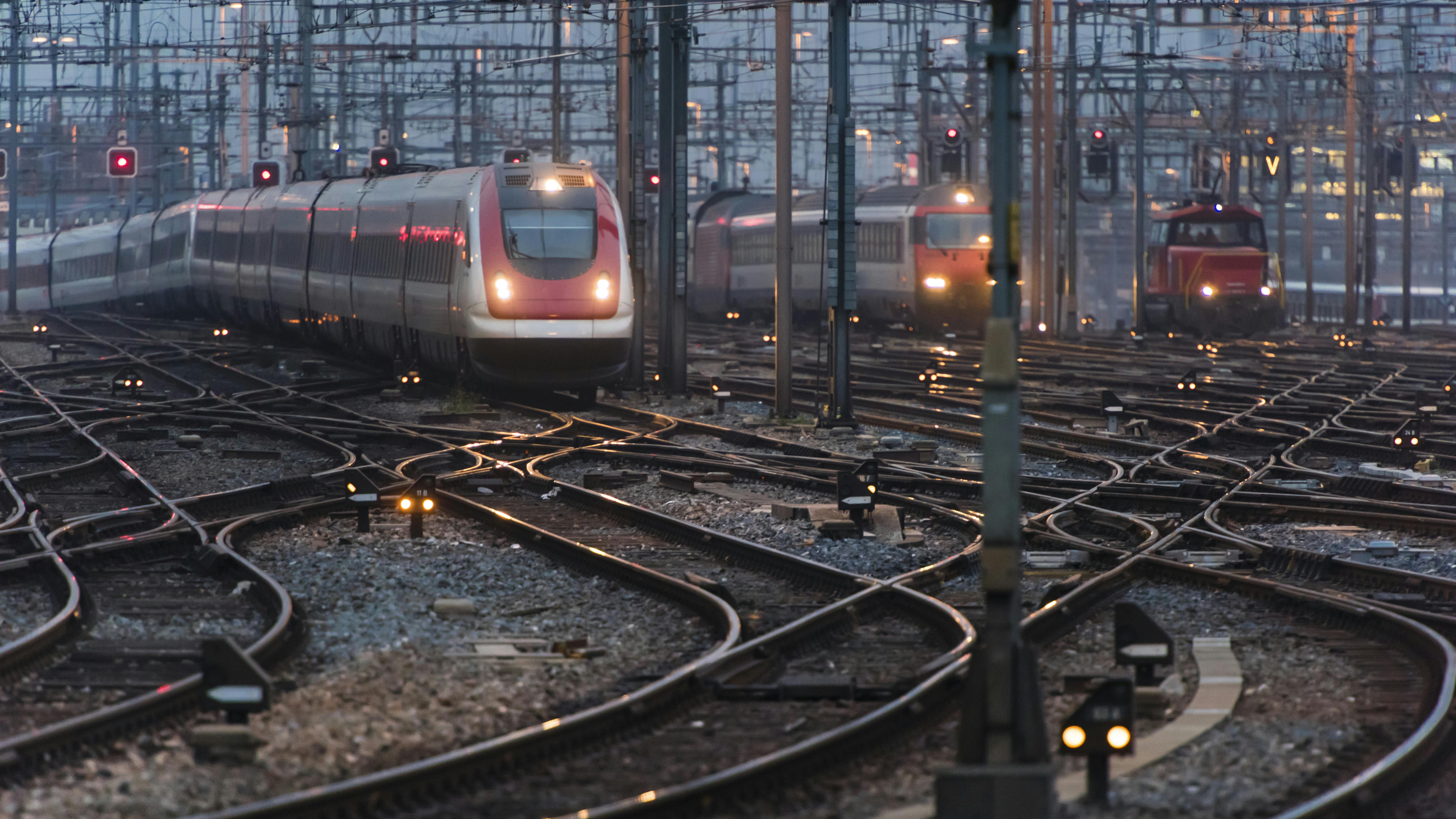 train sits on tracks near depot with switches and signals