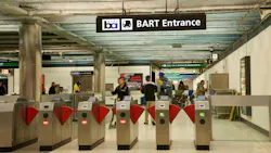 Entrance fare gates to Powell Street BART Station with people in station Entrance fare gates to Powell Street BART Station with people in station