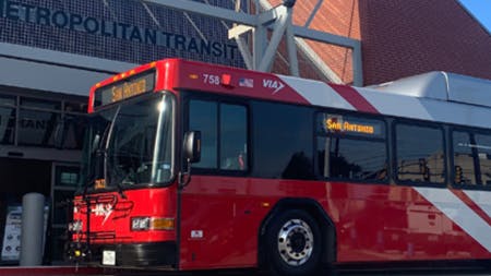 A VIA bus waits outside of a transit center.