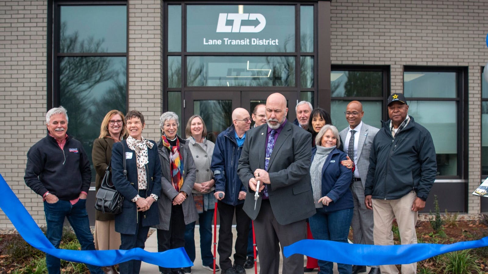 Local leaders stand behind a blue ribbon being cut in front of the operations command center.