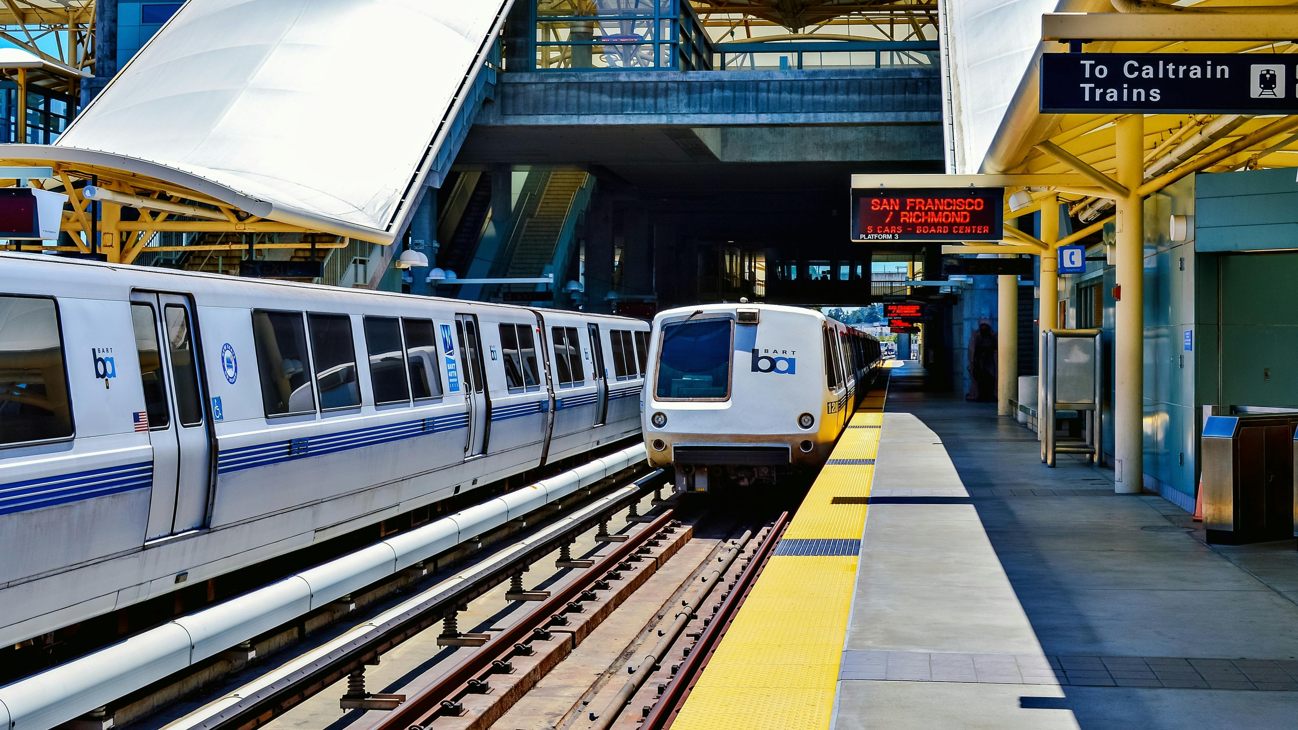 A BART train departs a station.