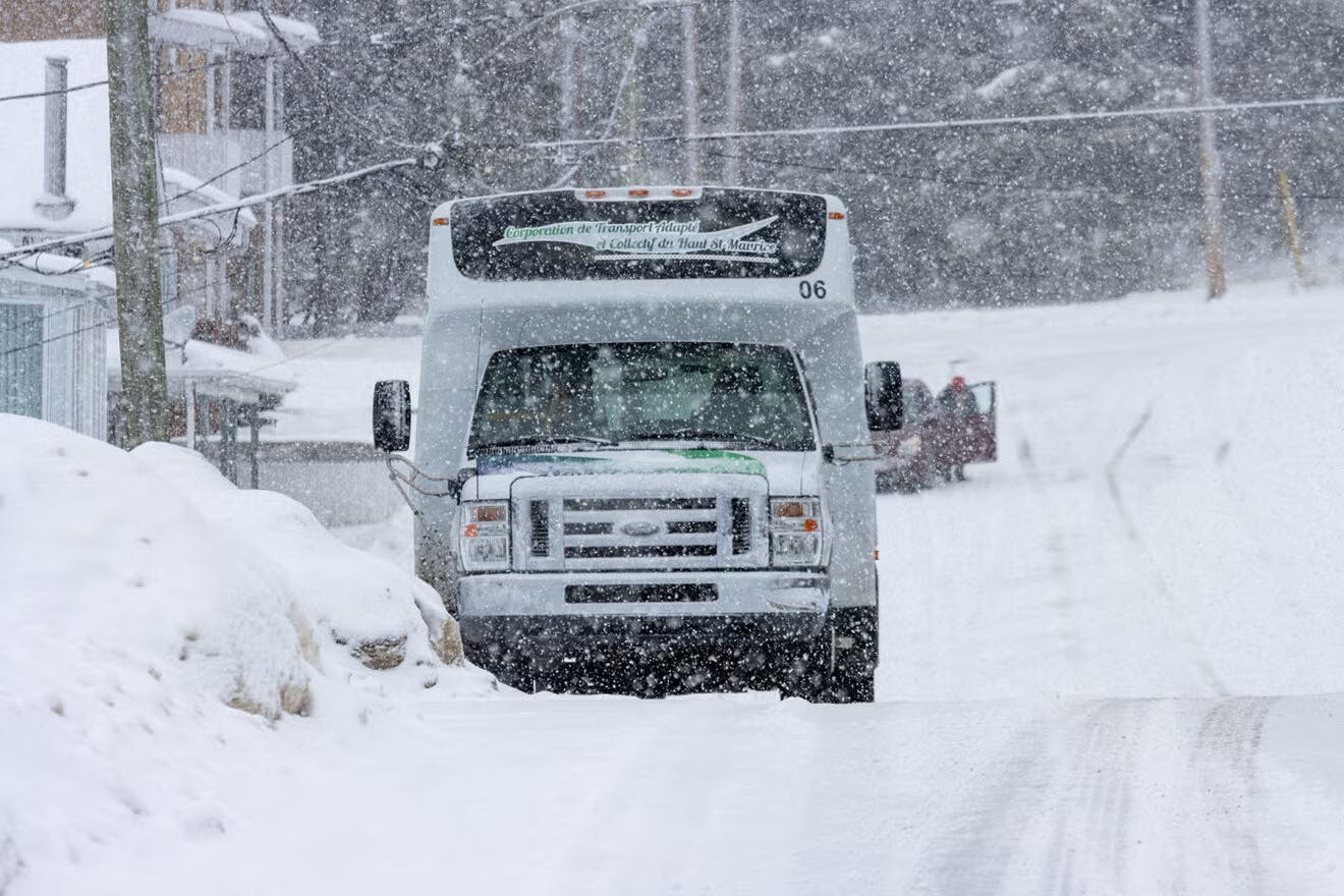 An on-demand transit vehicle drives through the snow.