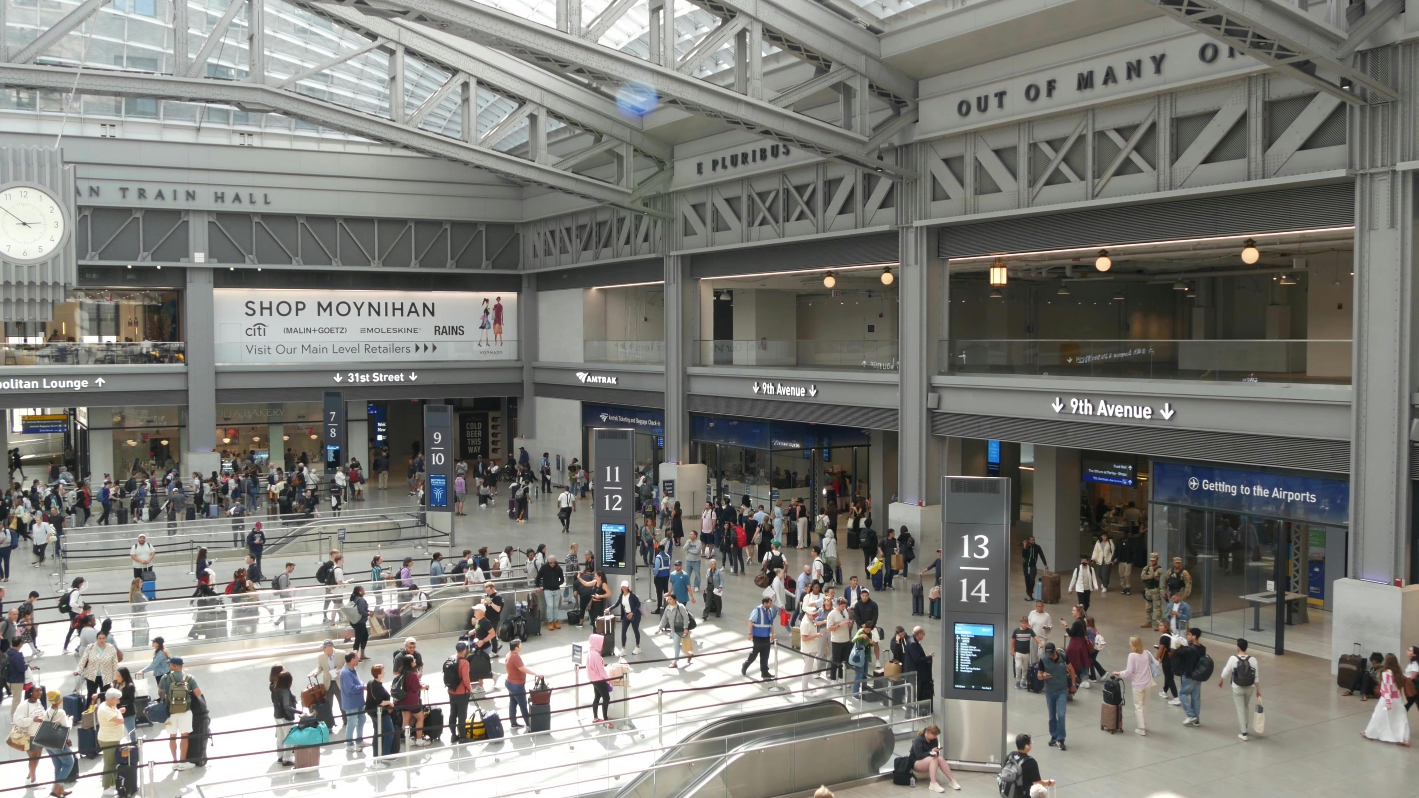 Passengers mill about Moynihan Train Hall.