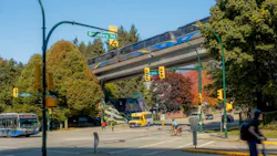 The image displays a bustling corner of Boundary Road, showing cars, a bus and an elevated train traversing through the scene. The image displays a bustling corner of Boundary Road, showing cars, a bus and an elevated train traversing through the scene.