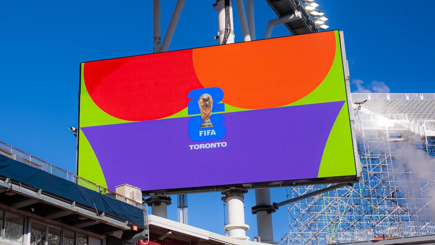 The image shows the FIFA World Cup 2026 Toronto logo on a stadium screen.