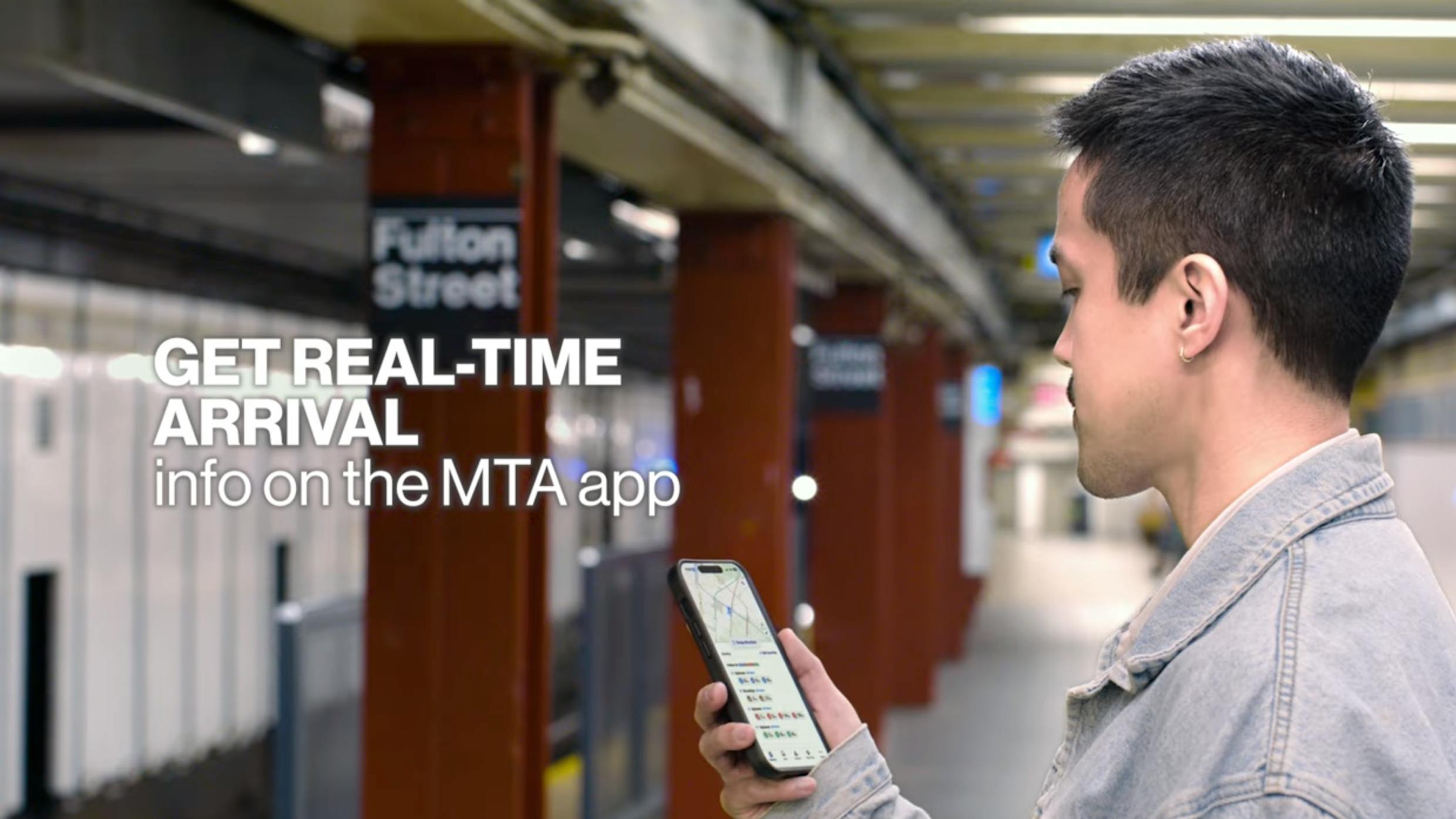 An MTA passengers checks arrival times on the new MTA app while standing on the Fulton Street platform.