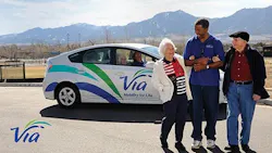 A Via operator stands with two passengers in front of a Via Prius. A Via operator stands with two passengers in front of a Via Prius.