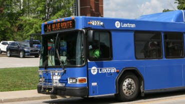 The image shows a Lextran bus moving down the street.