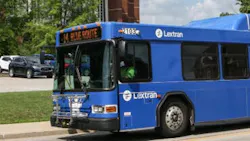 The image shows a Lextran bus moving down the street. The image shows a Lextran bus moving down the street.