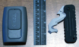 The VIEVU PVR-PRO2 shown with a ruler and a BLACKHAWK! Hawk Hook rescue tool. It's about the size of an old-style pager.