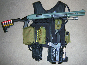 Shotgun and handgun 'system' resting on the vest that holds the rest.