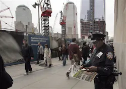 A New York City police officer looks at a copy of a newspaper featuring the image of Osama bin Laden, as she works adjacent to Ground Zero. A New York City police officer looks at a copy of a newspaper featuring the image of Osama bin Laden, as she works adjacent to Ground Zero.