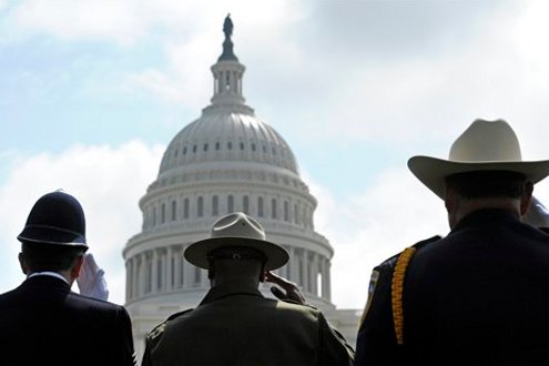 Police officers from Great Britain, left, California, center, and Arizona salute during the 13th annual National Peace Officer's Memorial Service.