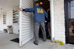 A DEA agent enters the pharmacy where four people were killed in a shooting on June 19. A DEA agent enters the pharmacy where four people were killed in a shooting on June 19.
