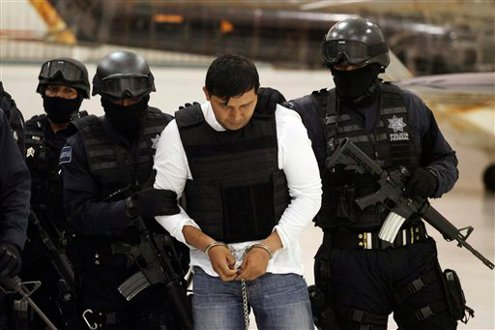 Federal Police agents escort Jesus Enrique Aguilar in Mexico City.