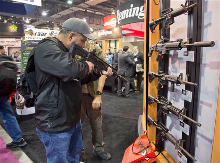 Stuart Konicar looks down the sight of a Remington Adaptive Combat Rifle on display at the Remington Defense exhibit during the SHOT Show on Jan. 15 in Las Vegas.