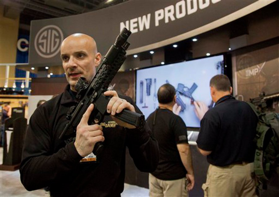 Sig Sauer representative Adam Painchaud explains one of the company's newest products, the MPX 9mm pistol caliber submachine gun at the 35th annual SHOT Show on Jan. 15 in Las Vegas.