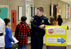 Police Officer Jeff Strack smiles at children changing classrooms at Jordan Elementary School in Jordan, Minn. Police Officer Jeff Strack smiles at children changing classrooms at Jordan Elementary School in Jordan, Minn.