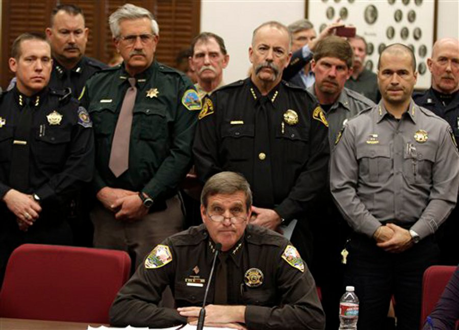 Weld County Sheriff John Cooke, center, backed by a group of fellow sheriffs, testifies against proposed gun control legislation in the Colorado Legislature at the State Capitol.