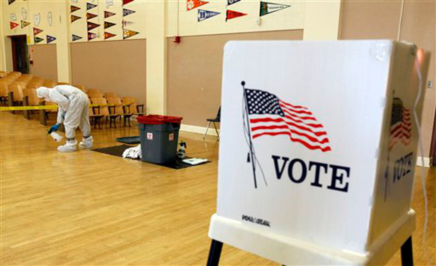 A 92nd Street Elementary School employee cleans up blood after a shooting at a polling station in Los Angeles on March 5.