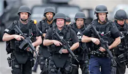 A SWAT team marches through a neighborhood while searching for a suspect in the Boston Marathon bombings in Watertown, Mass. on April 19. A SWAT team marches through a neighborhood while searching for a suspect in the Boston Marathon bombings in Watertown, Mass. on April 19.