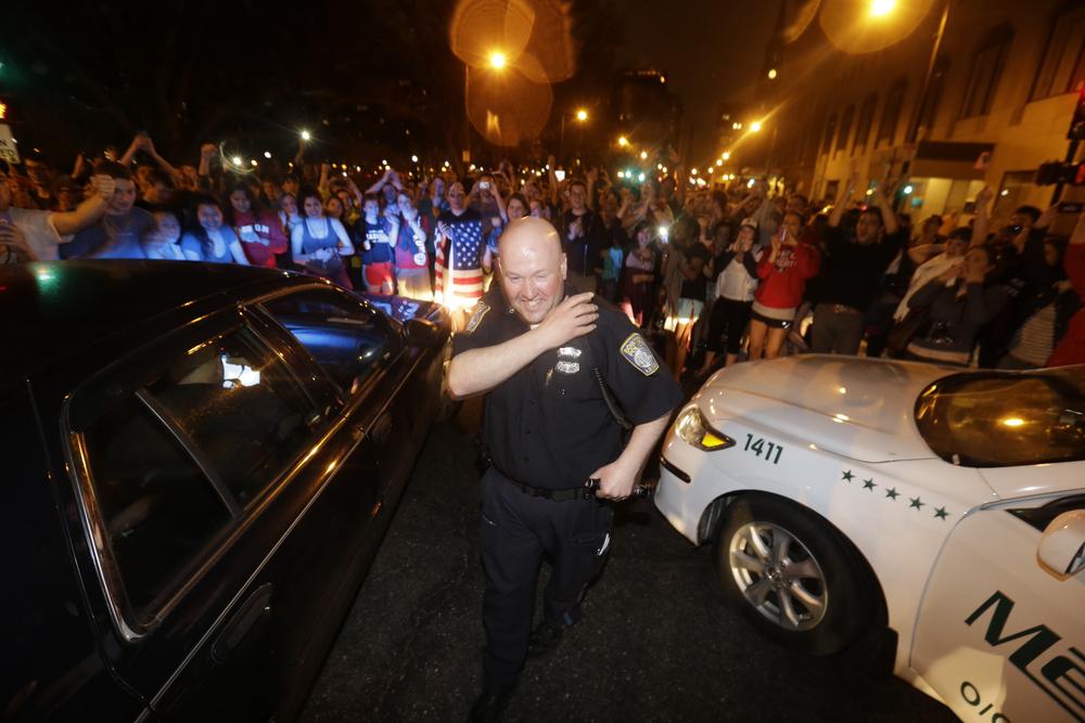 A police officer reacts to news of the arrest of one of the Boston Marathon bombing suspects on April 19.