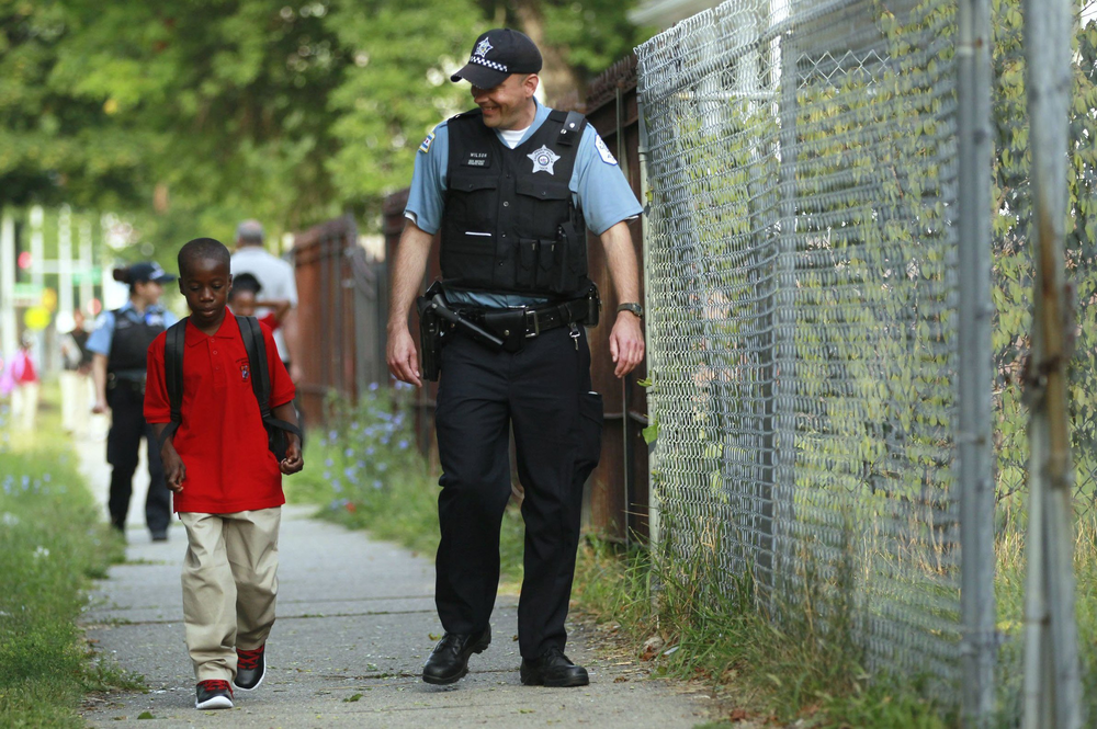 William Hawkins, a third-grader, is escorted by Chicago Police Officer Joe Wilson on Aug. 26.