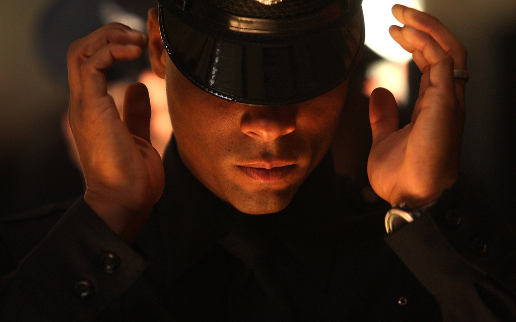 Los Angeles Police recruit Clay Bell adjusts his hat while preparing for a badge ceremony at the LAPD Elysian Park training academy.