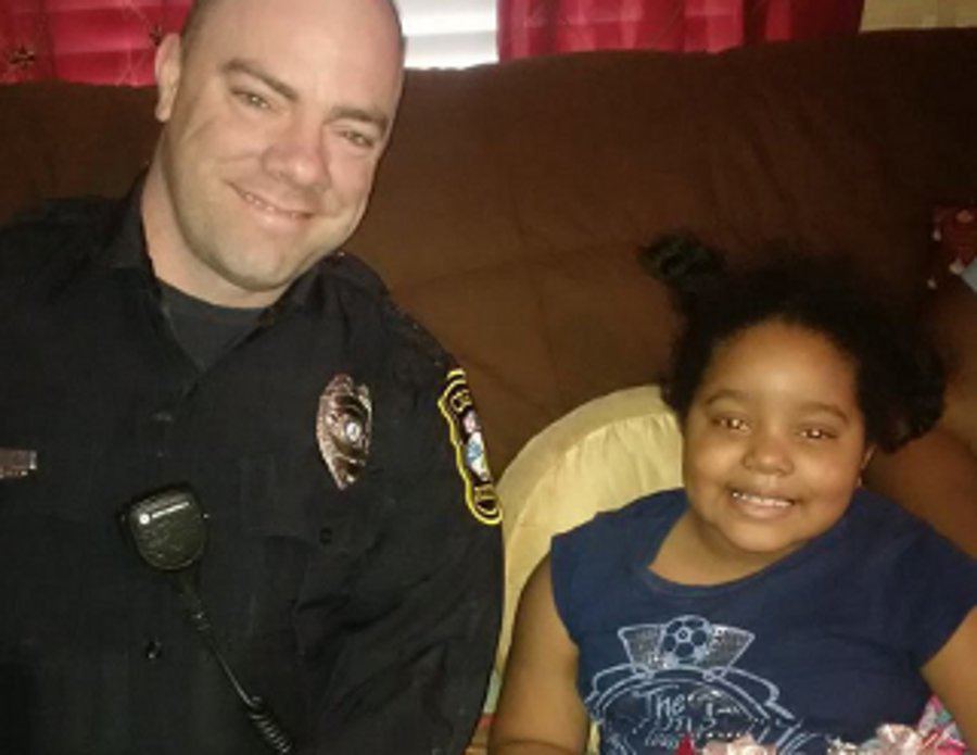 Officer Baxter Stegall is seen with 6-year-old Najah Zarif
