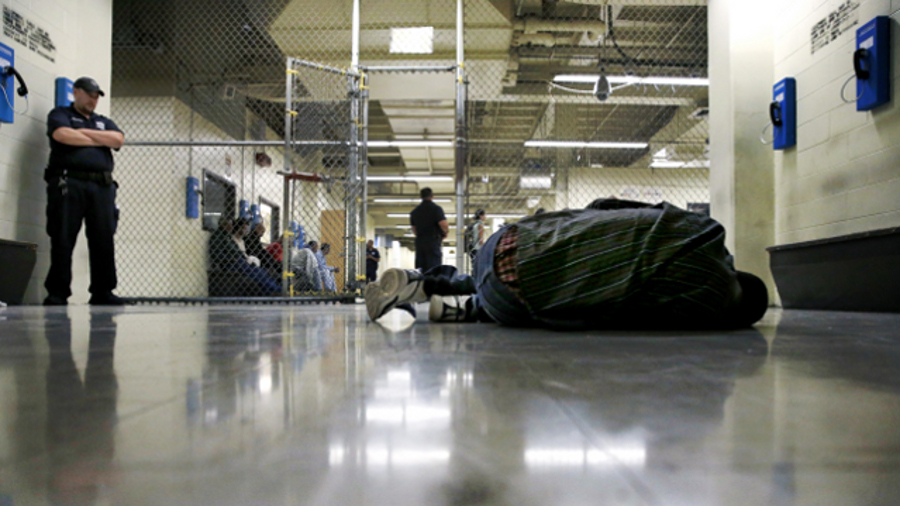 A man being booked into the Cook County Jail in Chicago sleeps on the floor of a holding pen while he awaits intake interviews.