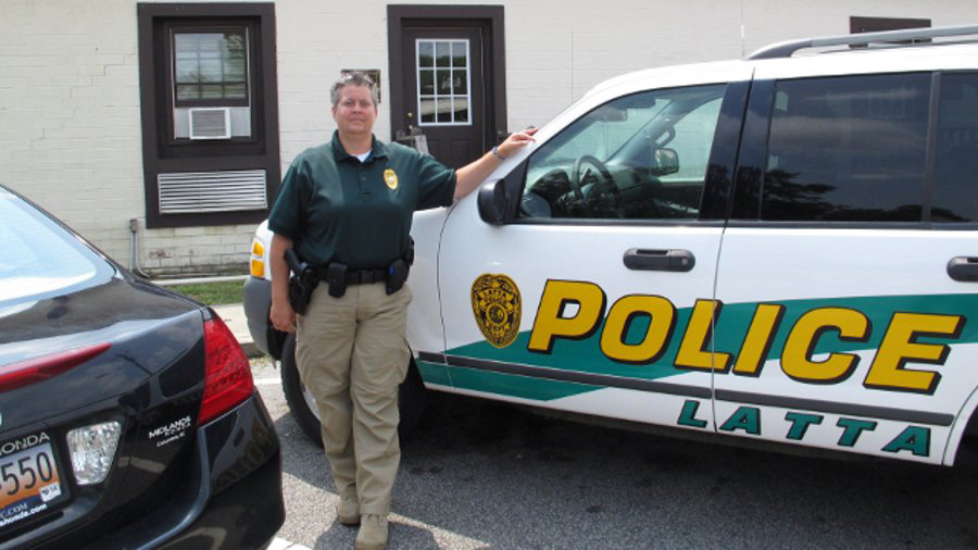 Latta Police Chief Crystal Moore stands beside her police SUV July 10.