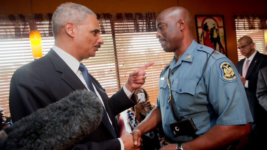Attorney General Eric Holder talks with Capt. Ron Johnson of the Missouri State Highway Patrol at Drake's Place Restaurant on Aug. 20 in Florrissant, Mo.